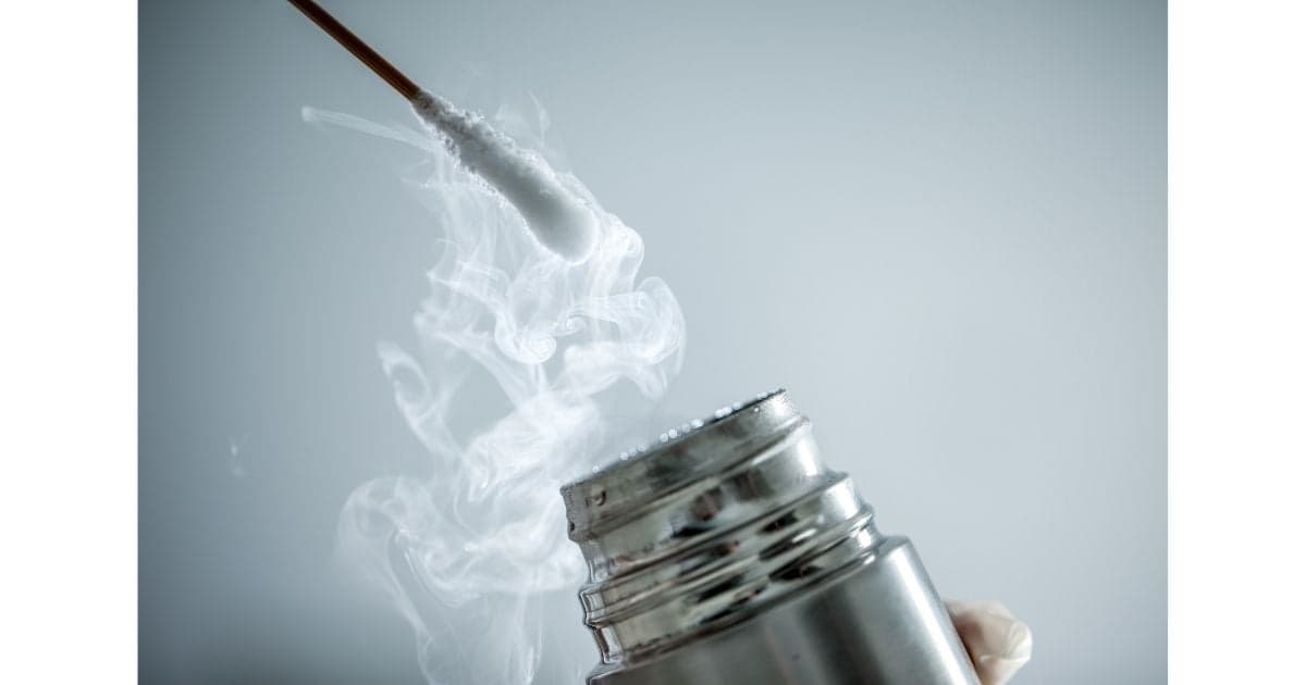 A cotton-tipped applicator above a liquid-nitrogen container with visible cold vapor.